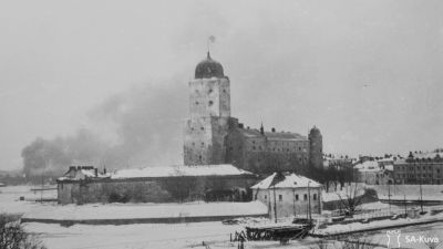 Viborg slott med finska flaggan höjd medan Viborg stad brinner i bakgrunden under slutskedet av vinterkriget. SA-kuva.