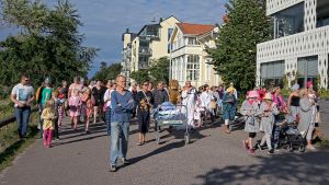 Många deltagare är klädda i pyjamas eller maskeraddräkt. En grupp människor går, iklädda pyjamas, och drar en säng där en sjusovare gömmer sig under ett lakan.
