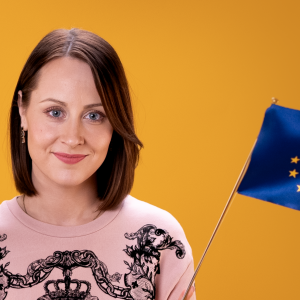 Toimittaja Kia Löfberg heiluttaa Suomen ja EU:n lippua.