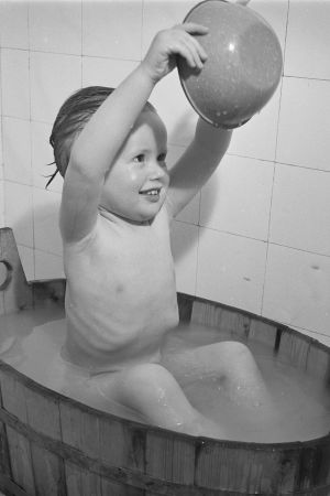Glad i bad! Lilla Ritva Kyytinen tar sig en omgång. Året är 1949. Svartvit bild på en liten flicka som badar i en träbalja.