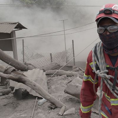 Guatemalalainen pelastustyöntekijä auttamassa tulivuorenpurkauksen uhreja.