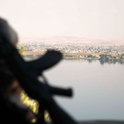Turkin tukemien syyrialaisjoukkojen taistelija katseli joen toiselle puolelle kurdien hallitsemalle alueelle Awshariyahin kylän lähistöllä Pohjois-Syyriassa. Lauantaina yhteenotoissa kuoli 15 ihmistä sotaa tarkkailevan järjestön mukaan.