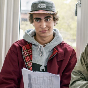 Marlon Langeland som Jonas i Skam. Jonas och Isak med mösor på framför ett fönster.