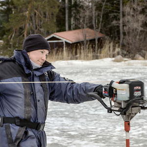 Man behöver åtminstone inte borra hål i isen för hand numera. Fiskaren Tanja Åkerfelt drar igång isborren på vintern ute på isen en bit från stranden.