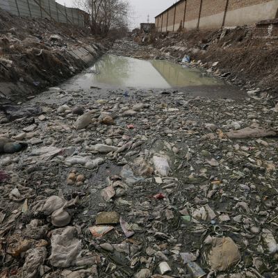 Jätemuovin saastuttama joki Pekingissä. Kuva vuodelta 2016.