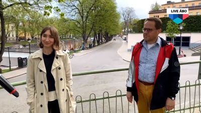 Två personer står vid Aura ås strand.