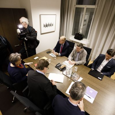 Pöydän ympärillä PAM:n entinen puheenjohtaja Ann Selin (edessä vasemmalla), valtiosihteeri Raimo Luoma sekä entinen valtakunnansovittelija Jukka Ahtela. Pöydän toisella puolella istuivat entinen SAK:n puheenjohtaja Lauri Ihalainen (vasemmalla), eläköitynyt EK:n työmarkkinajohtaja Lasse Laatunen sekä valtiosihteeri Valtteri Aaltonen (pöydän takana oikealla).
