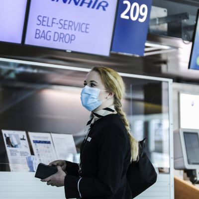 Kuvassa on suu- ja nenäsuojainta käyttävä Finnairin työntekijä.