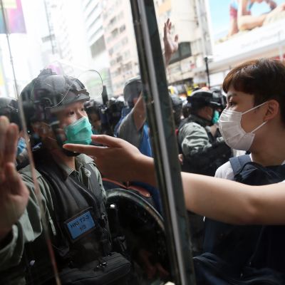 Mellakkapoliisi ja mielenosoittajat kohtaavat Hongkongissa.