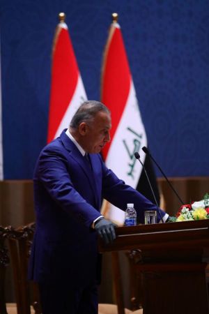 Iraks nya premiärminister Mustafa Kadhemi (i blått i mitten) anländer till förtroendeomröstningen i parlamentet. Kadhemi lovade i sitt första tal som premiärminister att ta itu med coronapandemin, nyval och Iraks urusla ekonomin.