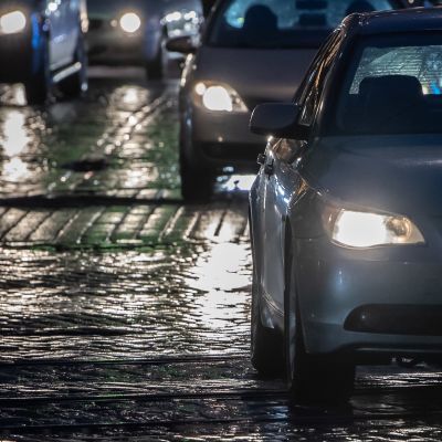 Autoilijoita illan hämärässä vesisateessa..