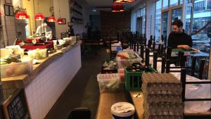 Restaurangerna måste nu göra sig av med råvaror som inte kommer att gå åt. En tom restaurang där en man ordnar med råvaror i olika lådor placerade på ett av borden.