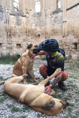 Björn Roos tillsammans med ett par hundar. Björn Roos från Borgå med gatuhund under sin roadtrip i Europa