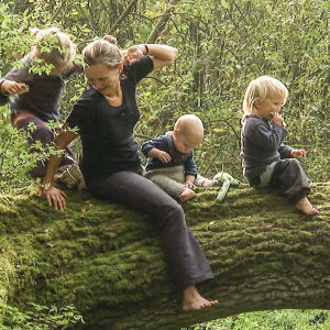 Familjen sitter på en trädstam ute i skogen