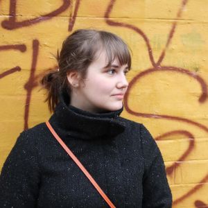 Amanda Mylläris kompisar fick inget meddelande i Coronablinkern trots att de umgåtts under exponeringstiden. en kvinna framför en gul vägg med röd grafitti på iklädd svart jacka