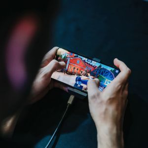 Mies pelaa mobiilipeliä