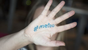 Kvinna håller upp sin hand där det står #metoo.