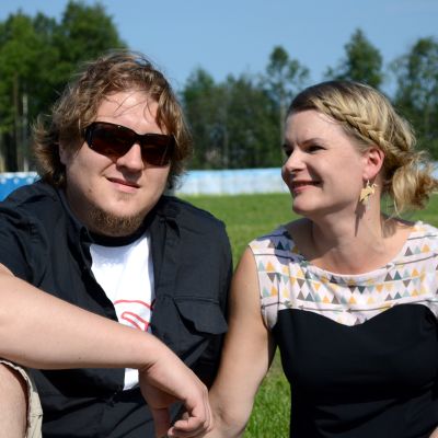 Matti ja Helena Poukkanen istuvat nurmikolla.