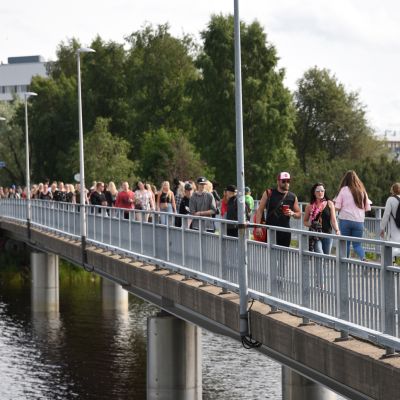 Yleisöä saapumassa Pikisaarensiltaa pitkin Oulun Qstockiin.