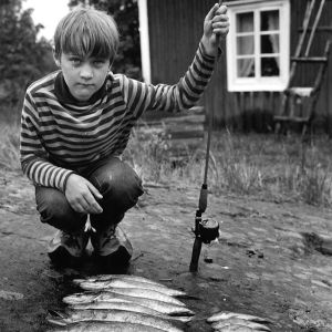 Tomi Salmela lapsena Kemiössä kalansaaliin kanssa.