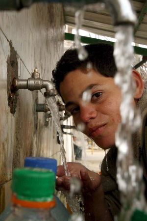 Palestinsk pojke fyller vattenkanistrar i södra Gaza Palestinsk pojke fyller vattenkanistrar på flyktingläger i södra Gaza