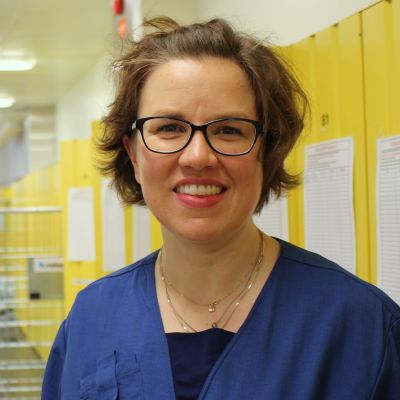 Sairaanhoitaja Riitta Mertanen sairaalan pukukaapeilla
