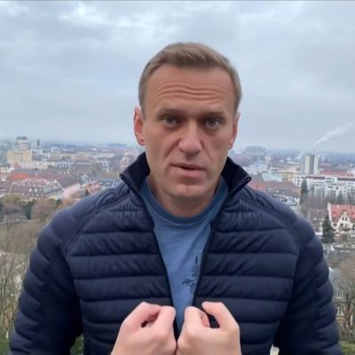 Navalnyj i lätt dunrock med en stad i bakgrunden.