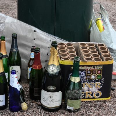 Tyhjiä alkoholipulloja ja käytettyjen ilotulitteiden pakkauksia.
