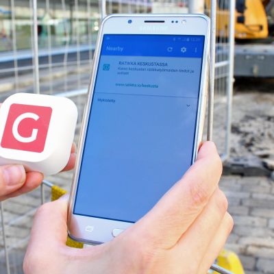 Kännykkä pienen Bluetooth-majakan vieressä.