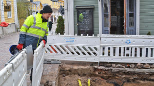 Juuso Koskinen övervakar arbetet. Det här är en av de största utgrävningarna han har deltagit i. En man i gul jacka lutar sig över ett staket och tittar ner i en grop. Han står i gamla stan i Borgå.