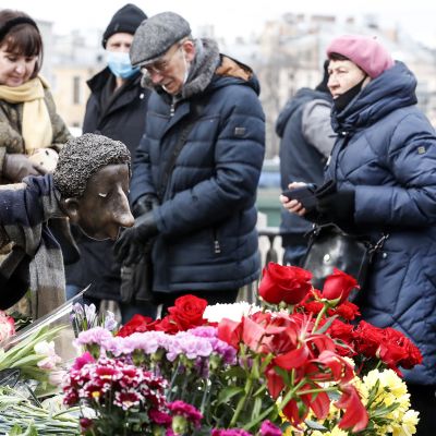 Ihmiset tuovat kukkia enkelipatsaalle joka on omistettu koronaan kuolleille terveydenhoitohenkilöstölle.