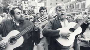 Bellmantolkarna Cornelis Vreeswijk, Fred Åkerström och Gösta Skepparn Cervin på Vietnamdemonstration på Hötorget i Stockholm den 28 augusti 1965. Fred Åkerström i mitten med Cornelis Vreeswijk till vänster och Gösta Skepparn Cervin till höger på Vietnamdemonstration på Hötorget i Stockholm den 28 augusti 1965.