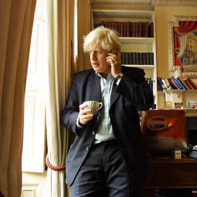 Boris Johnson toimistossa puhuen puhelimeen.
