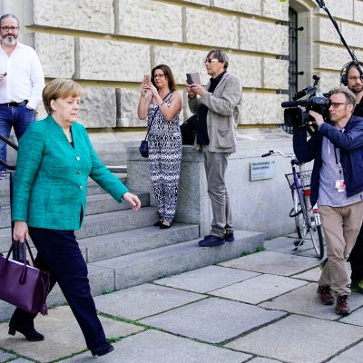 ihmiset kuvaavat ulos tulevaa Angela Merkeliä