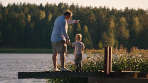 Far och son. Alkoholismen får ett ansikte i filmens slutskede. En man med sin lille son vid handen på en somrig brygga.