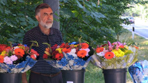 Ali Toy säljer blommor på den plats där hans tidigare chef mördades. Ali Toy säljer blommor på den plats där hans chef mördades.