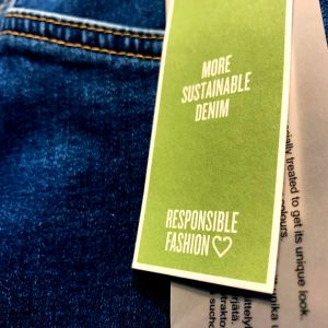 ett jeansplagg med en lapp som talar om att det är hållbart mode