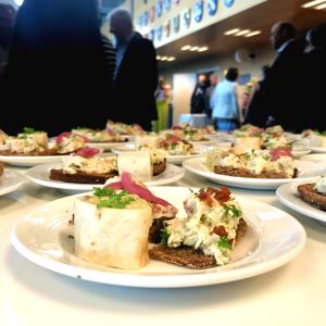 Det bjöds på både salt och sött när kommunerna skålade in den nya samkommunen. en massa småplock av mat uppradade på en bänk - i bakgrunden syns folk i kostymer