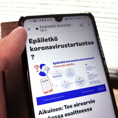 Kännykässä näkyvillä Helsingin kaupungin koronaneuvontasivut.