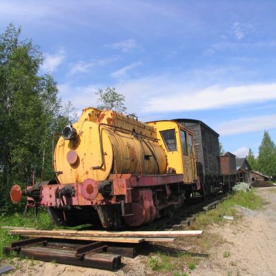 Keltainn Porter-höyrysäiliöveturi vaunuineen seisoo Pielsien museon ulkoalueella Lieksassa.