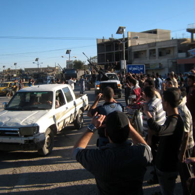Väpnade män paraderar på gatorna efter strider med irakiska styrkor.