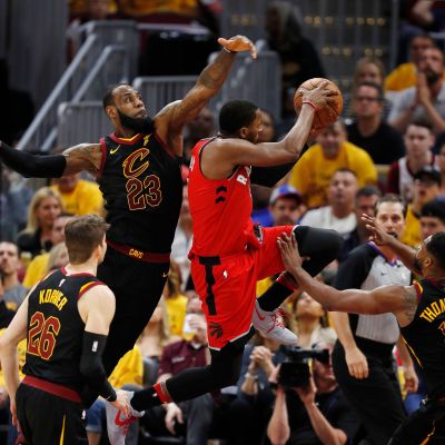 Toronton CJ Miles yrittää koria, Clevelandin LeBron James torjuntaa.