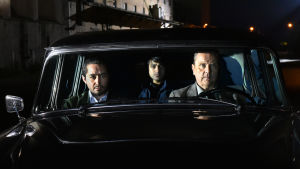 Tre män i en bil. Khaled, Mazdak och Wikström är en udda trio - men nog så effektiv Khaled (Sherwan Haji) Mazdak (Simon Al-Bazoon) och Wikström (Sakari Kuosmanen) sitter i en gammal bil och tittar rakt fram.