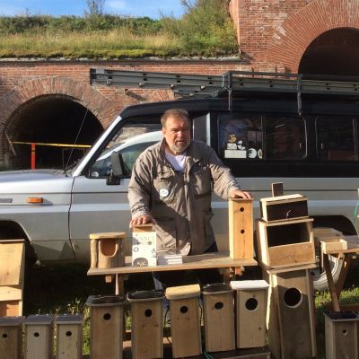 Urpo Koponen seisoo linnunpönttöjen takana Kyminlinnassa