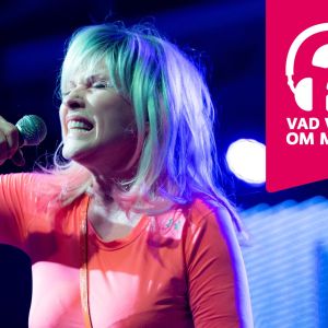 Debbie Harry i Blondie blundar och sjunger i en mikrofon.