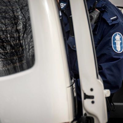 Poliisi poliisiauton sivuovella.