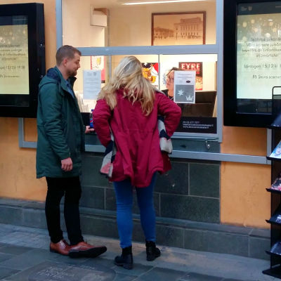 Två ungdomar, Jan Inberg och Daniela Ollus, köper biljetter vid Åbo Svenska Teaters biljettkassa, där Ghita Brunnsberg-Lerkki sitter.