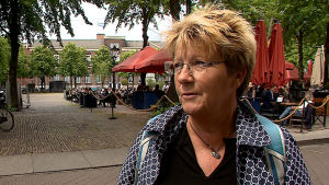 Jacqueline Beulink är nöjd med premiärminister Ruttes strama linje. Bild på Jacqueline Beulink som intervjuas på en gågata i Haag.