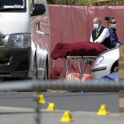 Den skjutne terrormisstänkte 18-åringen förs bort av medicinsk personal.