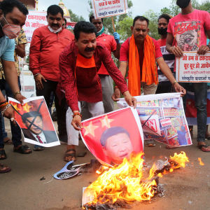Män bränner bilder på den kinesiska presidenten Xi Jinping.